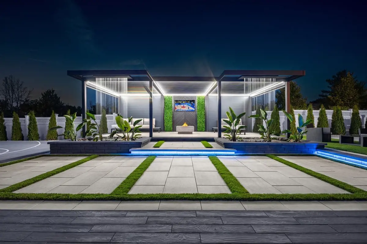 Contemporary backyard with geometric paver layout, accent lighting, and structured landscaping.