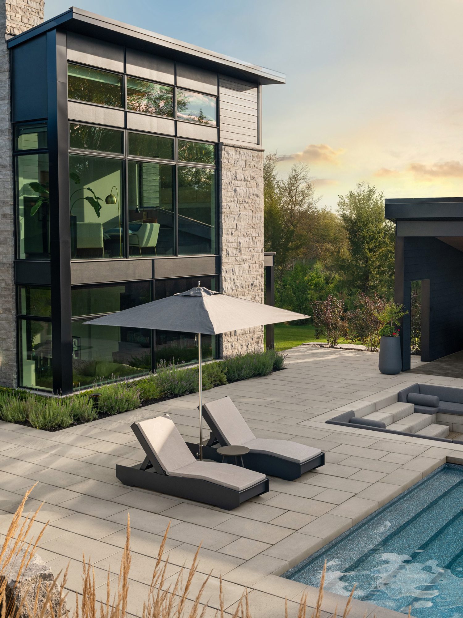 Seating wall finished with Raffinato Caps in Greyed Nickel, creating a clean architectural edge around the fire feature zone.