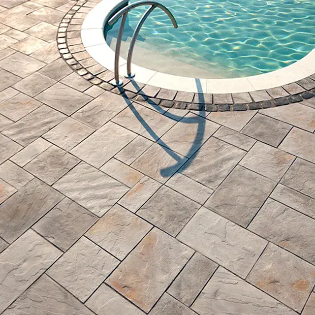 Inca Slabs by Techo-Bloc, large limestone-inspired patio slabs, arranged around a pool for a timeless, rustic look and durable outdoor space.