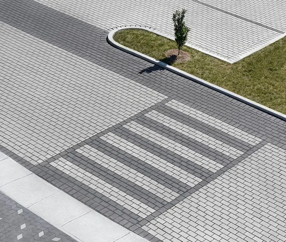 Place municipale en pavés Hydra de Techo-Bloc, gris et charbon, avec texture lisse et passages piétons intégrés.