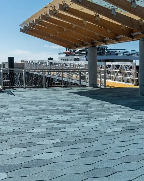 Pavés Hexa installés sous une structure moderne avec auvent, créant une surface à motifs audacieux dans un espace public.