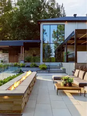 A contemporary patio with a fire pit and comfortable seating, featuring Para 500 × 750 Slab in Beige Cream and Graphix Wall in Beige Cream
