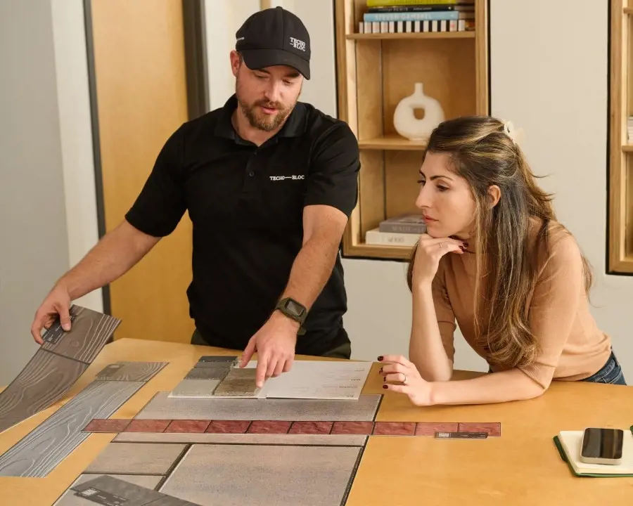 Techo-Bloc rep presenting paver samples to a customer at a table using a sample kit.