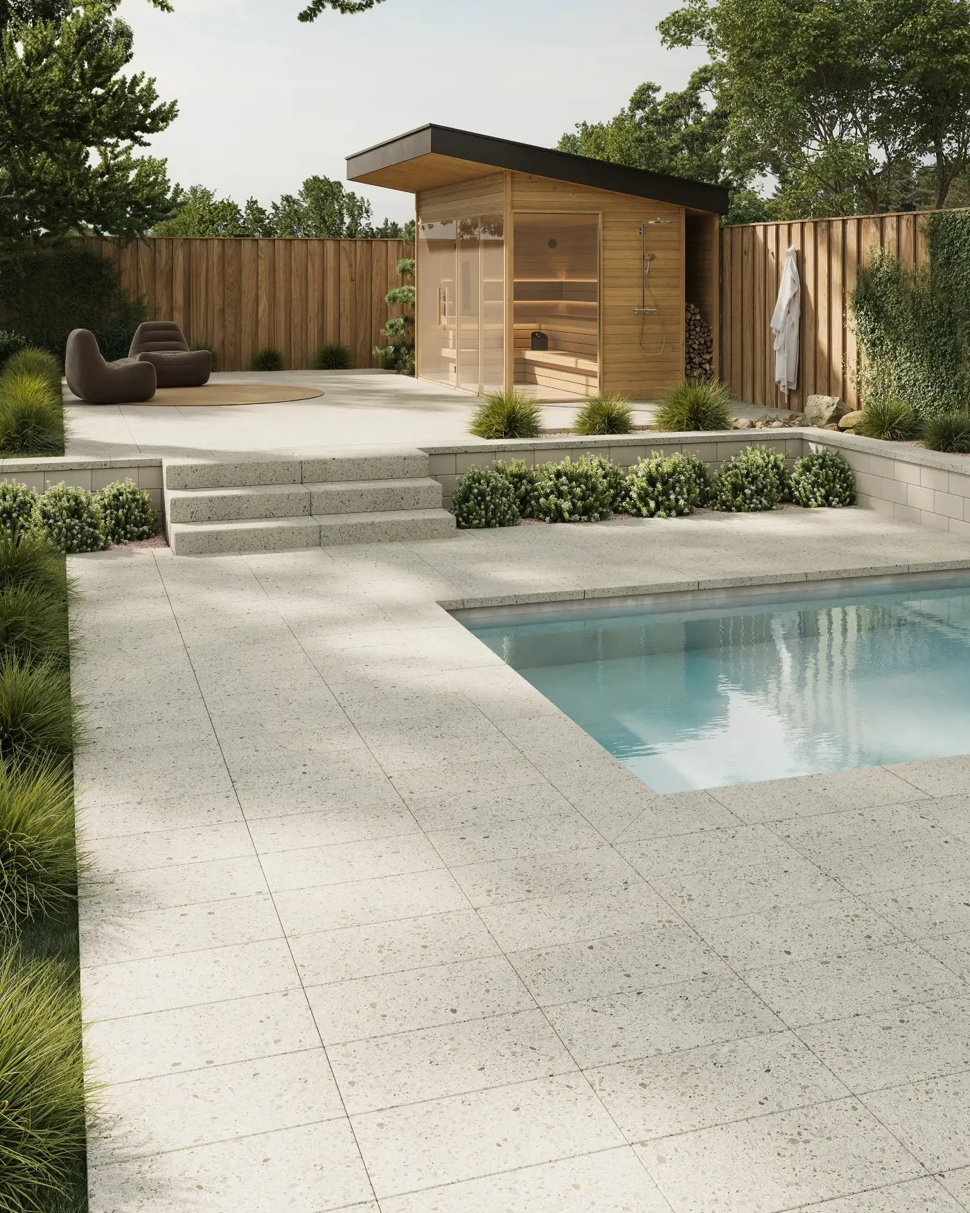Modern backyard pool and patio built with Techo-Bloc Terrazzo slabs in Stardust Beige, featuring matching concrete steps and caps for a seamless outdoor design.
