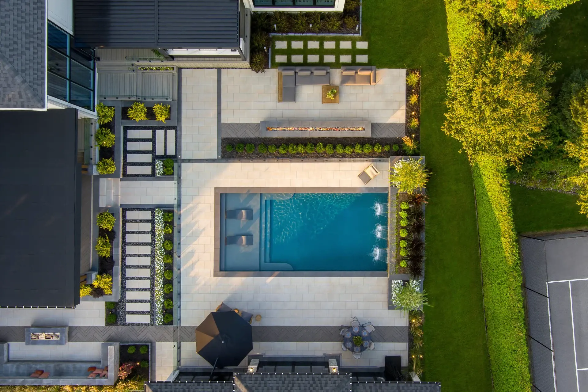 Aerial view of the redesigned backyard featuring a pool, structured patio layout, and modern seating zones.