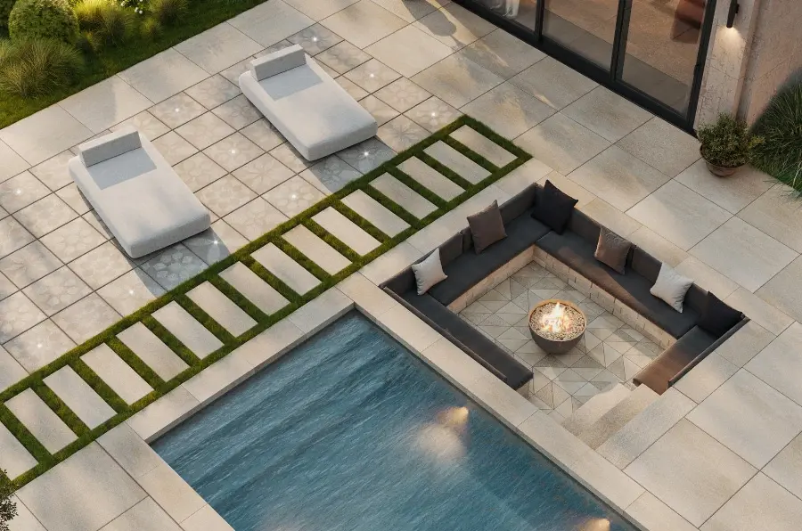 Vue rapprochée d'un coin salon extérieur comprenant un foyer encastré, une piscine et des chaises de patio.