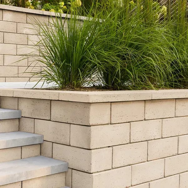 Travertina Raw by Techo-Bloc, luxurious travertine wall blocks forming a retaining wall with a smooth, natural finish, ideal for landscaping and outdoor features.