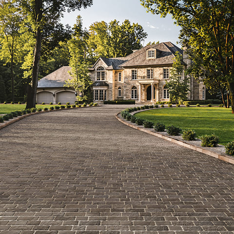 Saint-Oxford Pavers in a tight cobblestone pattern with earthy tones, creating a sophisticated, permeable driveway with excellent stain resistance.