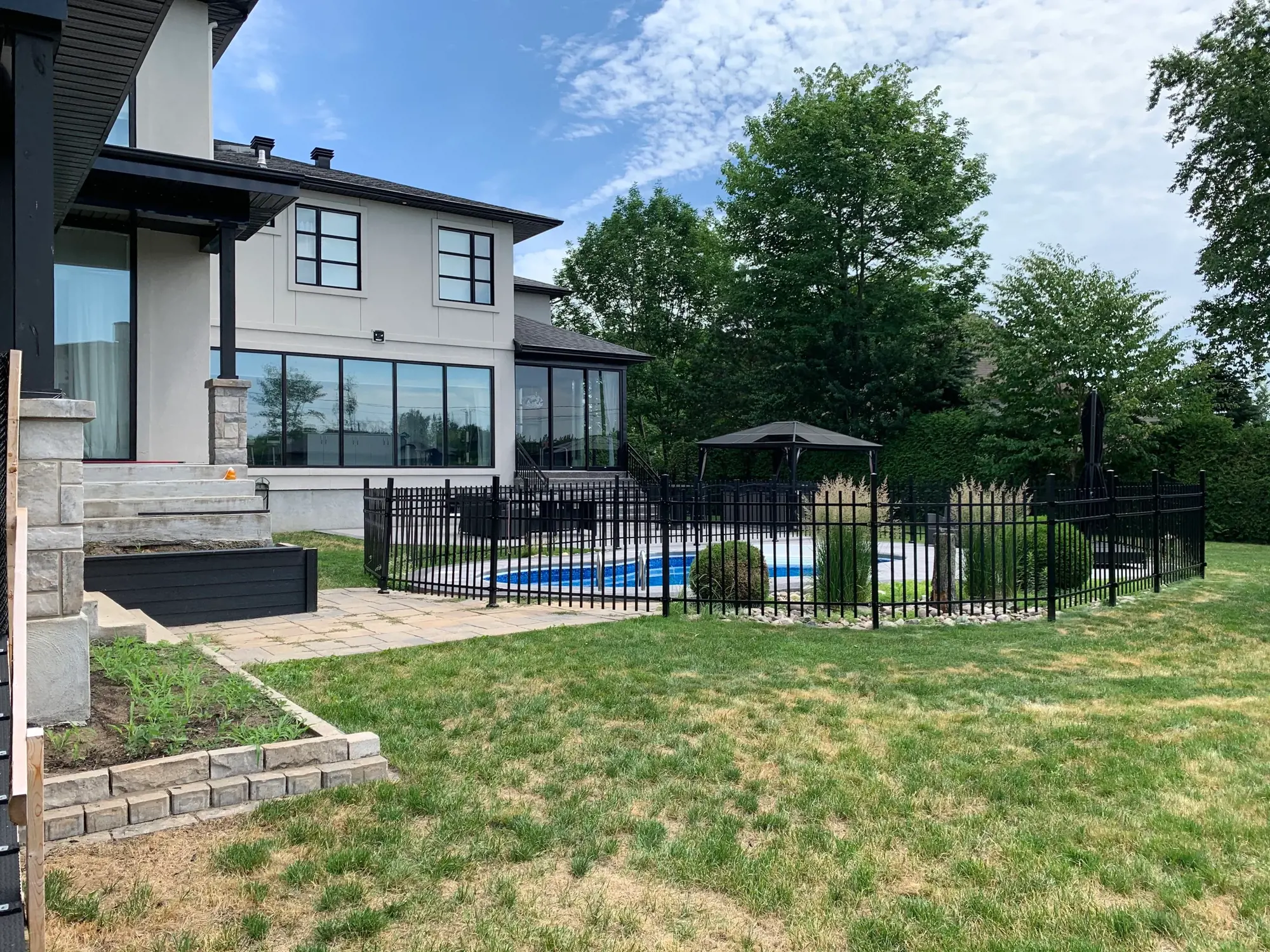 Backyard before renovation showing open grass area and unstructured landscaping.